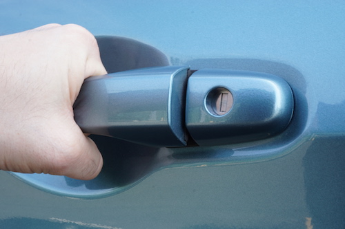 Person locked out of their car pulling on door handle