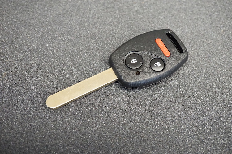 New car key on a grey pad it is a remote head high-security key